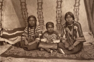 A group of native americans sitting on the ground.