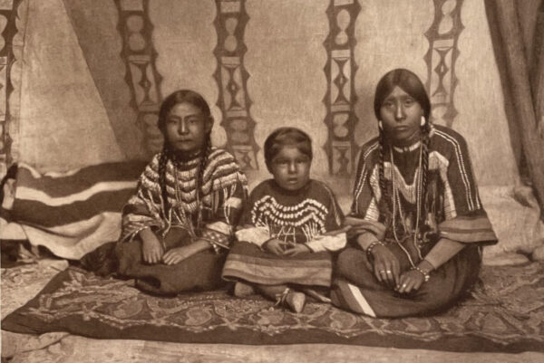 A group of native americans sitting on the ground.