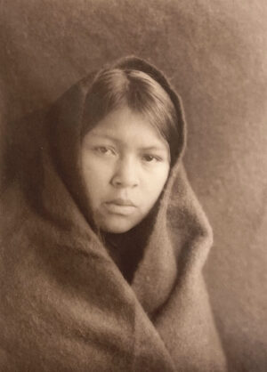 A young girl wrapped in a blanket.