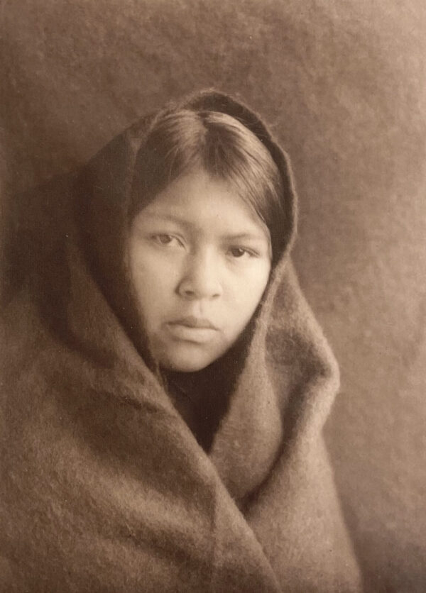 A young girl wrapped in a blanket.