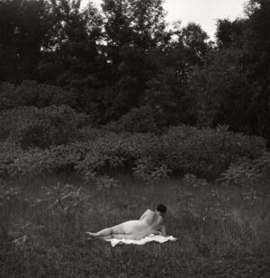 A man and woman laying in the grass.