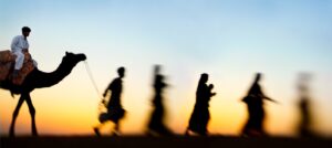 A blurry image of people walking in the desert