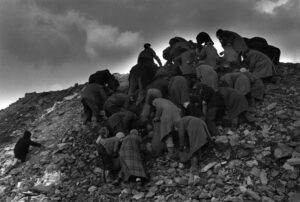 A group of people climbing up the side of a mountain.
