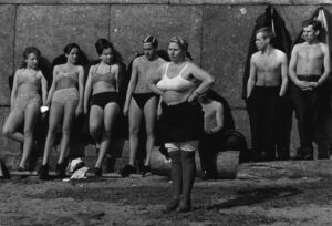 A woman in black and white bathing suit standing next to other women.