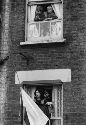 A woman looking out of an open window.