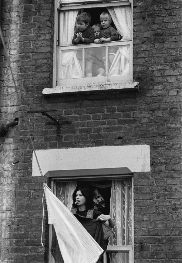 A woman looking out of an open window.