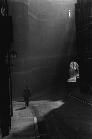 A man walking down the street in an alley.