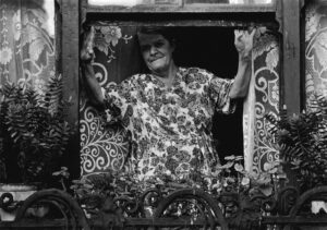 A woman standing in the window of her house.