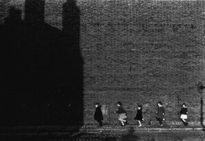 A group of people walking down the sidewalk.