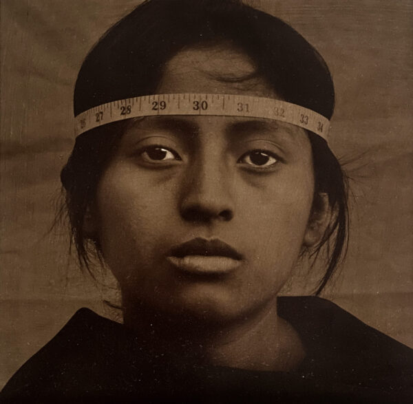 A young girl wearing a headband with measuring tape around her head.