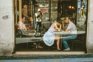 A group of people sitting at tables outside.