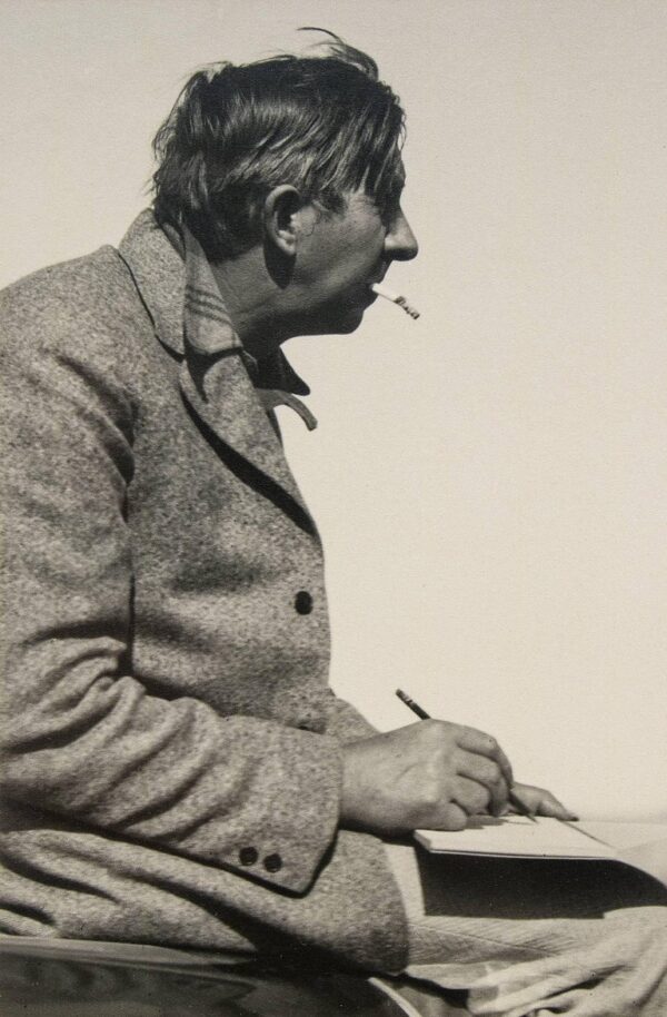 A man sitting down with a cigarette in his mouth.