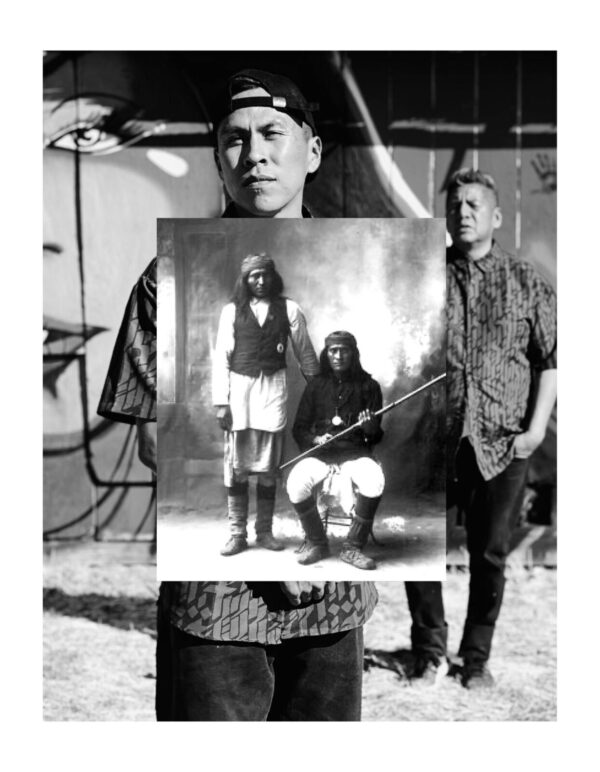 A man holding up an old photo of himself and his family.