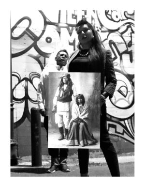 A woman holding up an image of herself and a man.