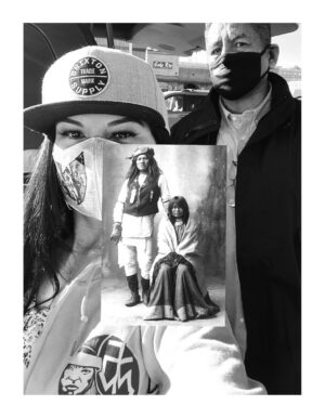 A woman holding up an image of two people.