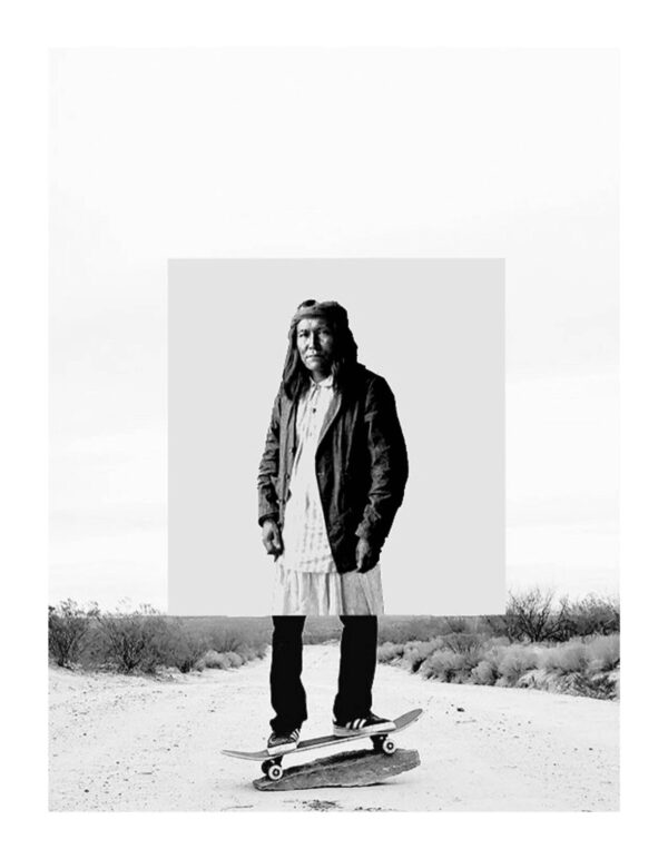 A man standing on top of a skateboard in the desert.