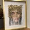 A framed picture of a woman 's face with hair.