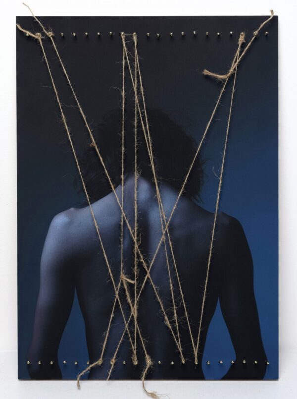 A man with his back turned and holding onto some string