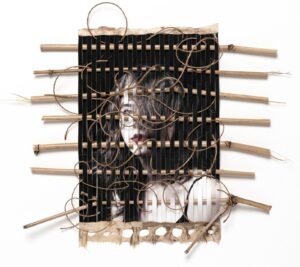 A wooden frame with many wires and a face.