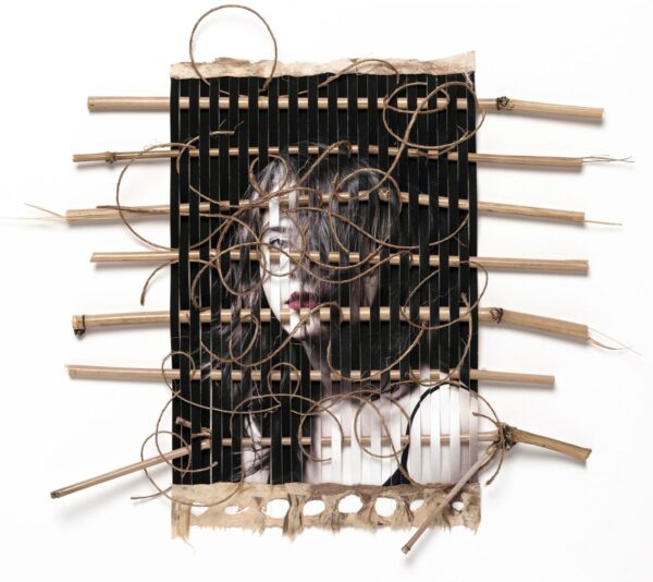 A wooden frame with many wires and a face.