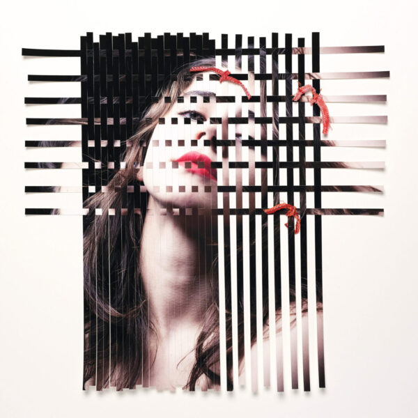 A woman with red lipstick is in front of black and white stripes.