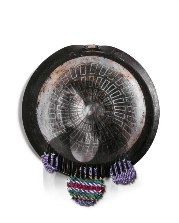 A person holding on to an old gong