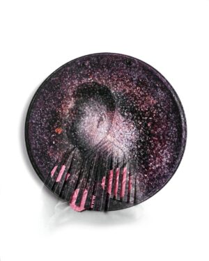 A round purple object with pink paint on it.