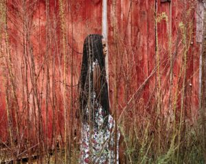 A woman standing in front of a red wall.