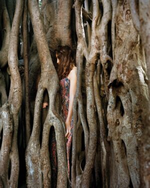 A woman standing in front of a tree.