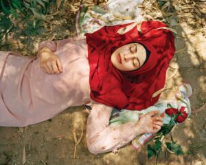 A woman laying on the ground with her head covered