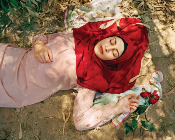 A woman laying on the ground with her head covered