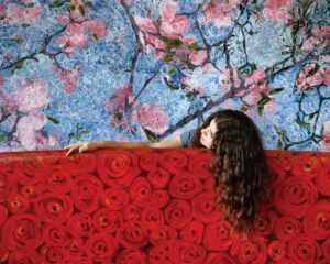 A woman leaning on the wall of roses