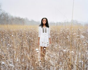 A woman standing in the middle of a field.
