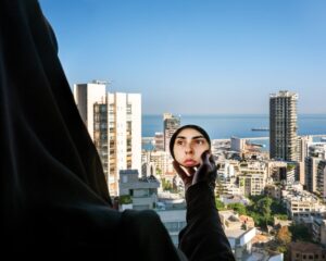 A person taking a picture of the city from a high rise.