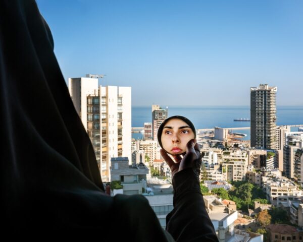 A person taking a picture of the city from a high rise.
