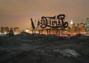 A large sign that is on top of some dirt.