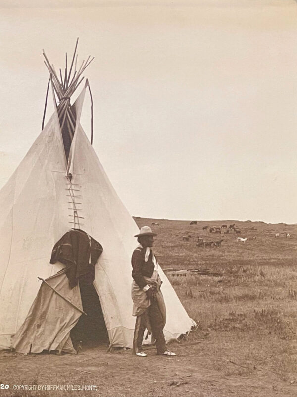 A man standing in front of a teepee.