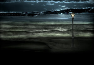 A lamp post on the beach at night