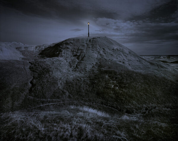 A cross on top of a hill in the dark.