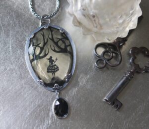 A necklace with a picture of a tree and a key.