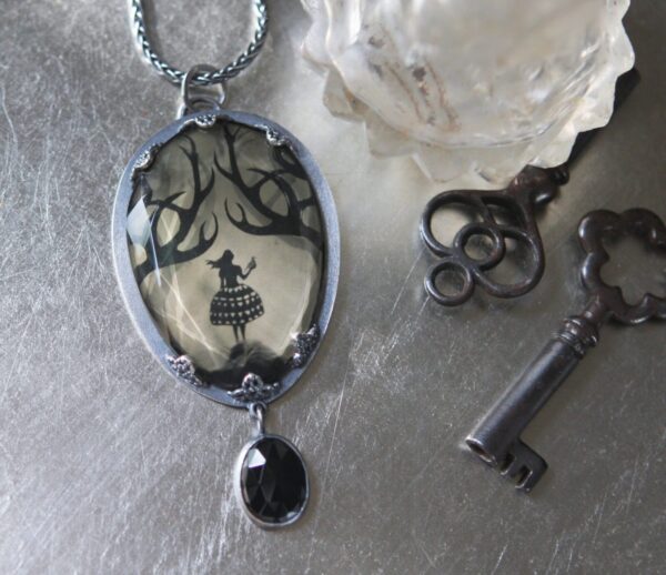 A necklace with a picture of a tree and a key.