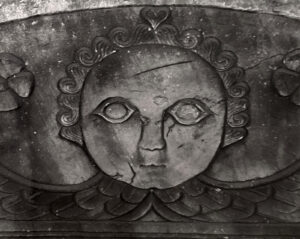 A black and white photo of a face on the wall.