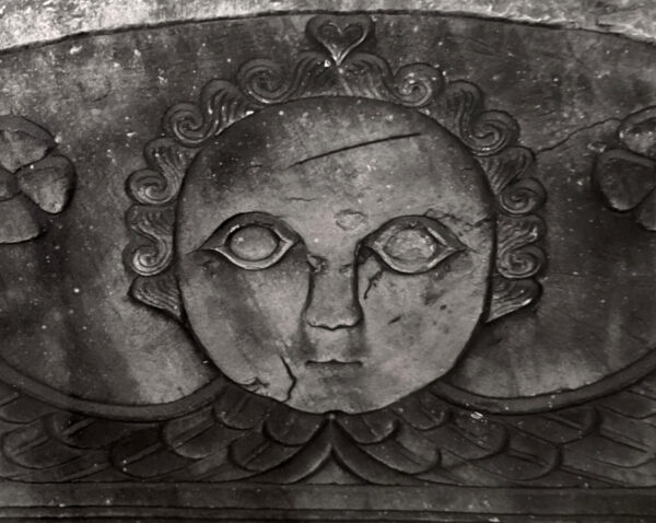 A black and white photo of a face on the wall.