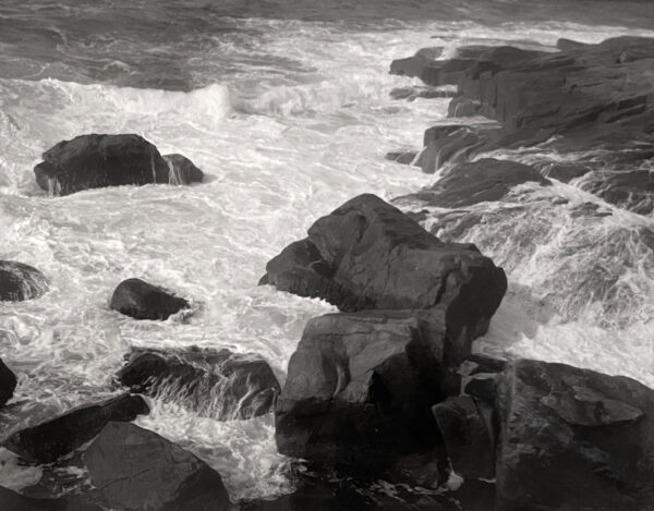 A black and white photo of rocks in the water.