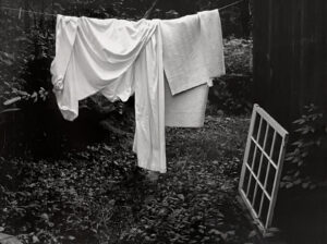 A black and white photo of clothes hanging on the line.