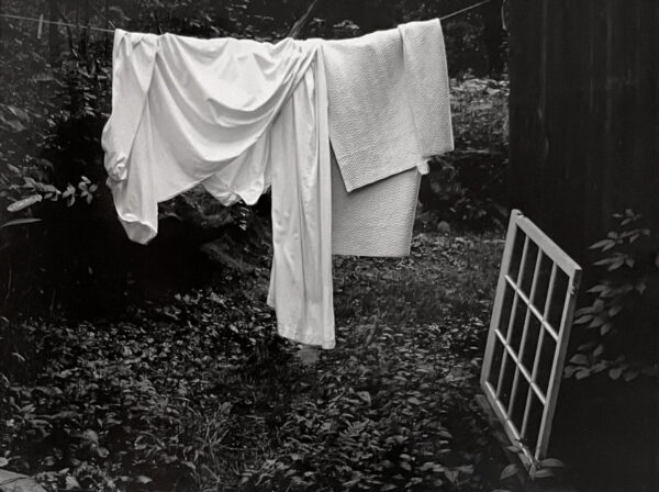 A black and white photo of clothes hanging on the line.