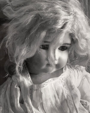 A doll with long hair and a white dress.