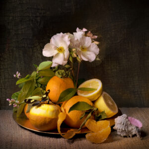 A plate with oranges and flowers on it