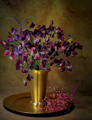 A vase of flowers on a table with other items.
