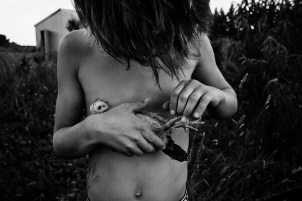 A woman holding a bird in her hand.